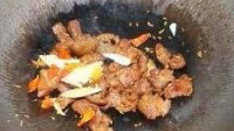孜然羊肉,放入辣椒干和蒜瓣,翻炒几下至孜然均匀的裹在羊肉上。
