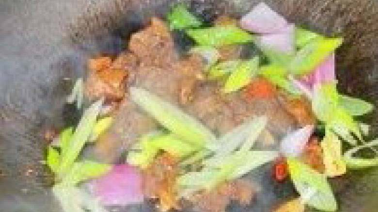 孜然羊肉,倒入洋葱和大葱,小炒一分钟,调入盐即可出锅食用!