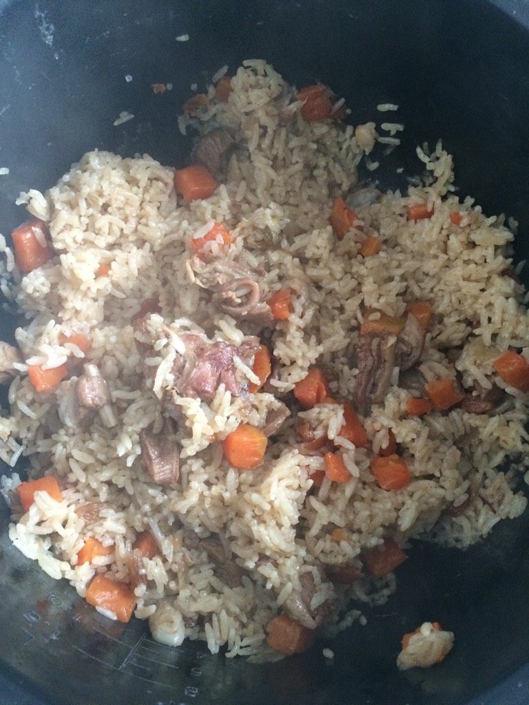 羊肉手抓饭,移至电饭锅，加入控水的大米，水不能多。按下煮饭键，水快干的时候加入<a style='color:red;display:inline-block;' href='/shicai/ 603'>葡萄干</a>搅拌一下。等饭跳了闷十分钟就可以了。