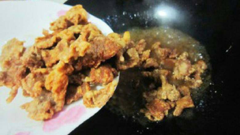 东北锅包肉,待汤汁冒小泡了加入明油一勺,将炸好的肉片下锅翻炒均匀出锅。