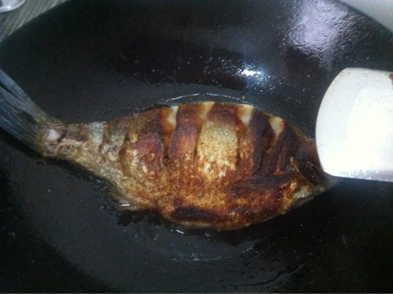 红烧鳊鱼,3.热锅放油,油热后放鳊鱼下锅煎,一面煎好后翻过煎另一面。如图