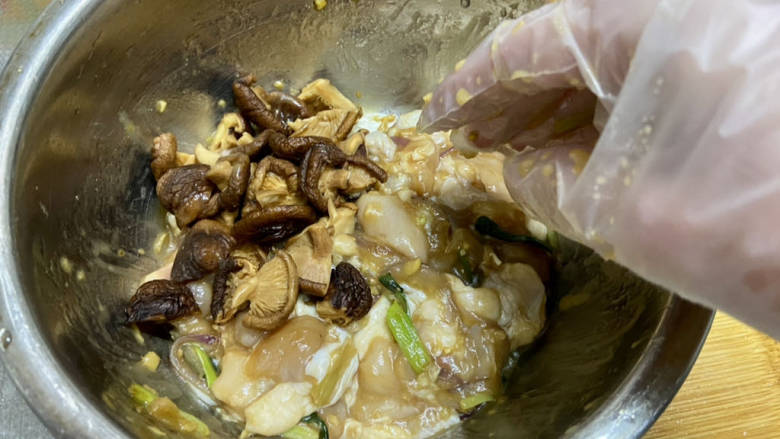 姜葱冬菇蒸滑鸡,加入香菇块,抓匀