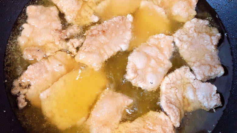 醋肉,锅中倒入油,加热至五成热,逐一下入肉片。