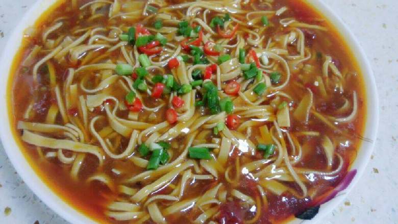 麻辣煮千张(豆腐皮),装盘后洒上葱花。