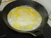 鸡蛋油条卷饼,打入一个鸡蛋,用筷子将膜挑破,鸡蛋均匀摸到面饼上。