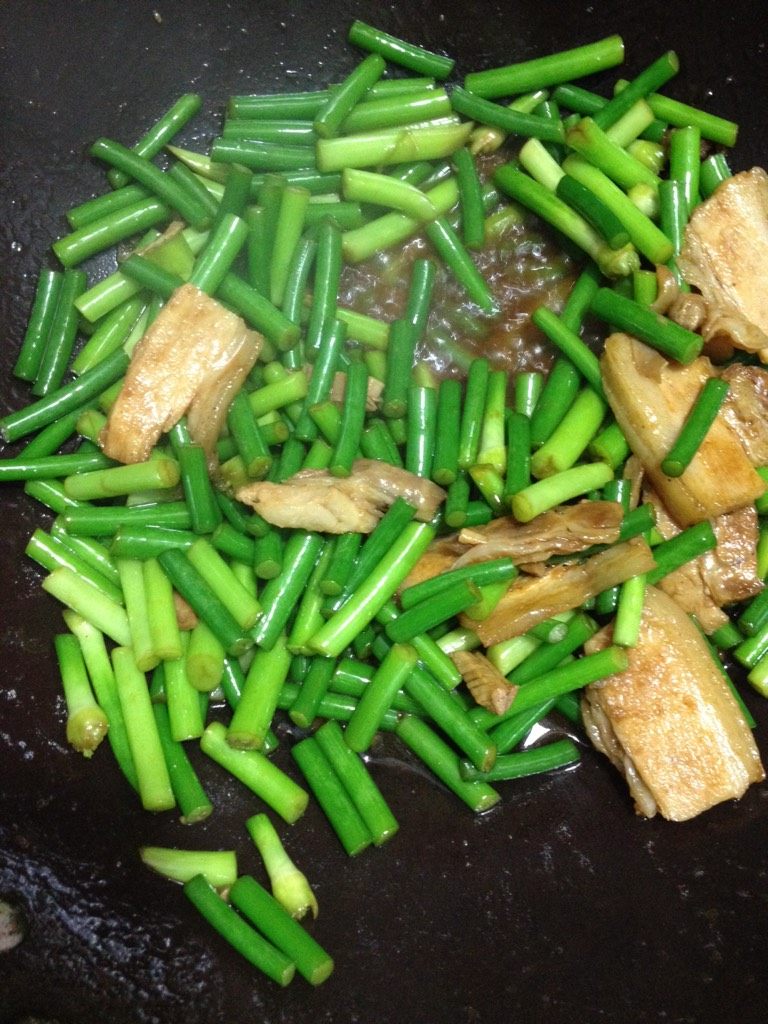 五花肉炒蒜薹,如图大火将蒜薹炒软，加入盐