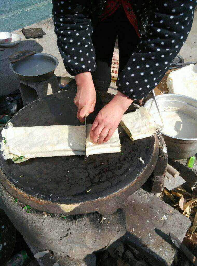 土法摊煎饼,用刀切好