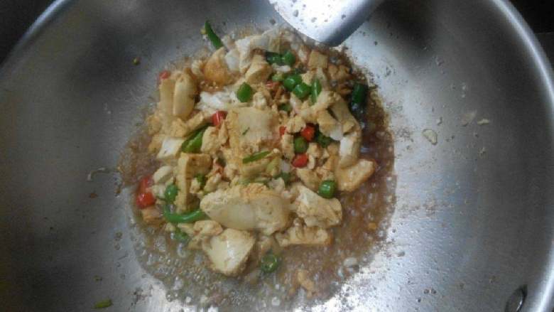 辣炒手工布包豆腐,把辣椒斜切,加入锅内翻炒,再加入酱油,少许盐