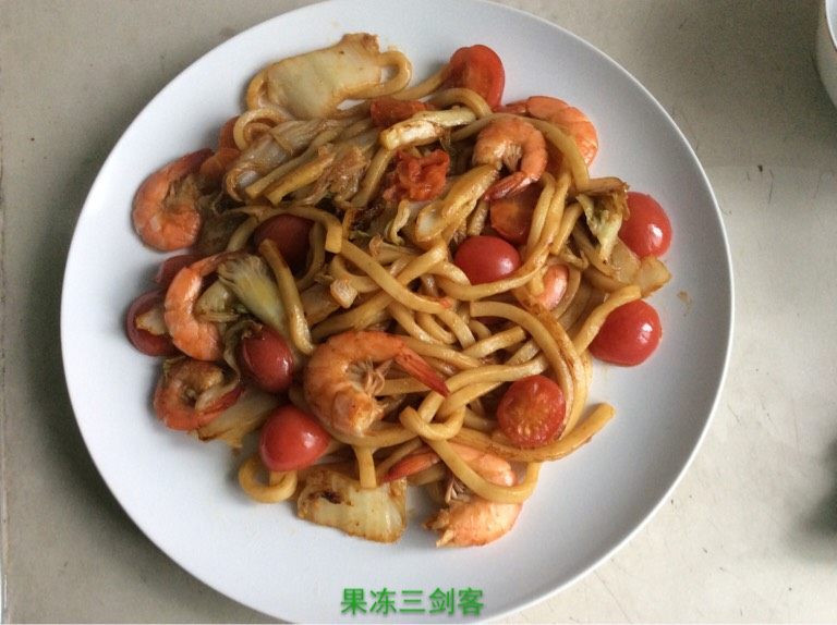 鲜虾炒乌冬面,中火，平底锅内放两小勺<a style='color:red;display:inline-block;' href='/shicai/ 851'>橄榄油</a>，等油六分热后，放大白菜，炒一分钟后放乌冬面和鲜虾，再添加<a style='color:red;display:inline-block;' href='/shicai/ 762'>老抽</a>，蚝油各两小勺。翻炒两分钟后加小番茄，再翻炒十五秒起锅。