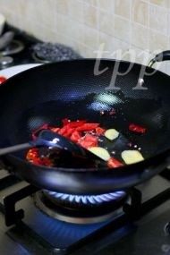 回锅牛肉,炒锅倒适量油,下入姜片,干尖椒,红椒,加小半勺盐,炒香