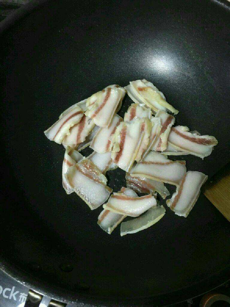 篱蒿炒腊肉,锅烧热放入腊肉炒出油。