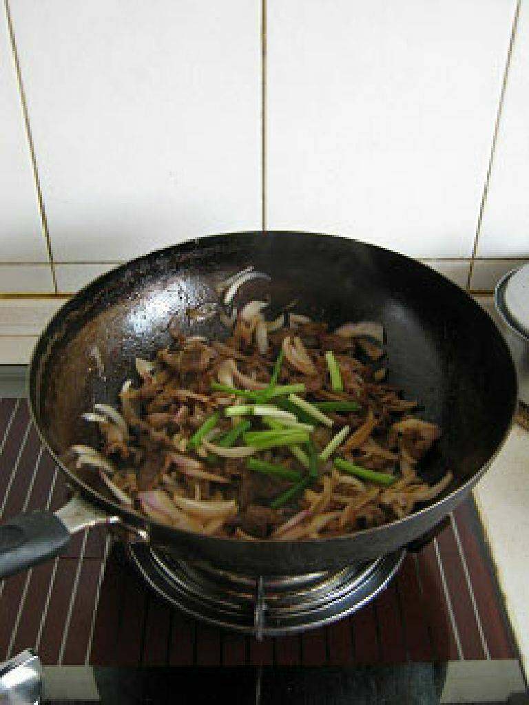 孜然羊肉片,再次加热锅中剩余的油，到4成热时放入洋葱炒出香味，然后放入之前炒好的羊肉片，淋入酱油、<a style='color:red;display:inline-block;' href='/shicai/ 146573'>孜然粒</a>、盐、<a style='color:red;display:inline-block;' href='/shicai/ 3729'>白糖</a>拌匀后炒出香味，最后在出锅前撒上<a style='color:red;display:inline-block;' href='/shicai/ 146542'>孜然粉</a>、香葱段拌匀即可。