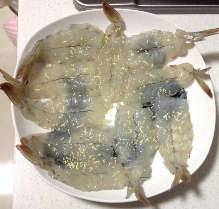 凤尾蝴蝶虾,虾去皮留虾尾，从背部片开，除虾线后，用刀拍扁，撒上<a style='color:red;display:inline-block;' href='/shicai/ 756'>鸡精</a>、<a style='color:red;display:inline-block;' href='/shicai/ 720'>胡椒粉</a>腌制10分钟
