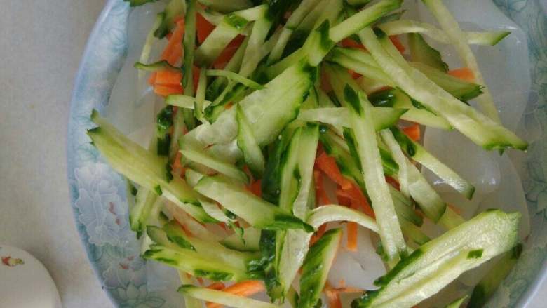 肉丝凉皮,将黄瓜丝和胡萝卜丝放到凉皮上，