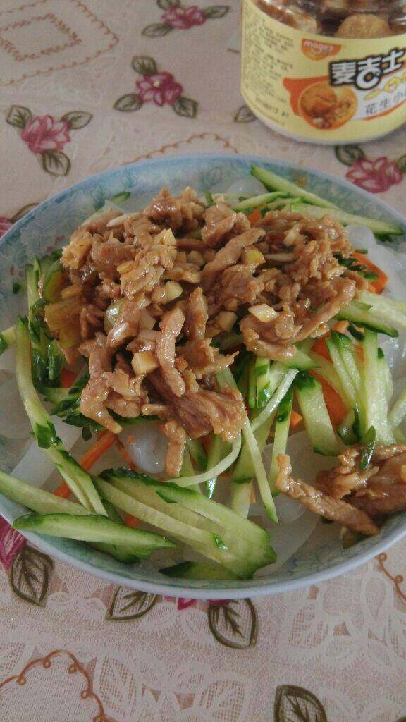 肉丝凉皮,将炒好的肉丝倒在黄瓜上，
