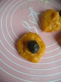 无油南瓜饼,把南瓜面团分成40克左右一个的小面团，取一份包入15克的黑芝麻馅。