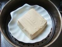 辣椒酱蒸豆腐,将内脂豆腐从盒中取出,要轻轻地才能尽量完整地取出,放到平的蒸盘中,用刀子轻轻切成片。