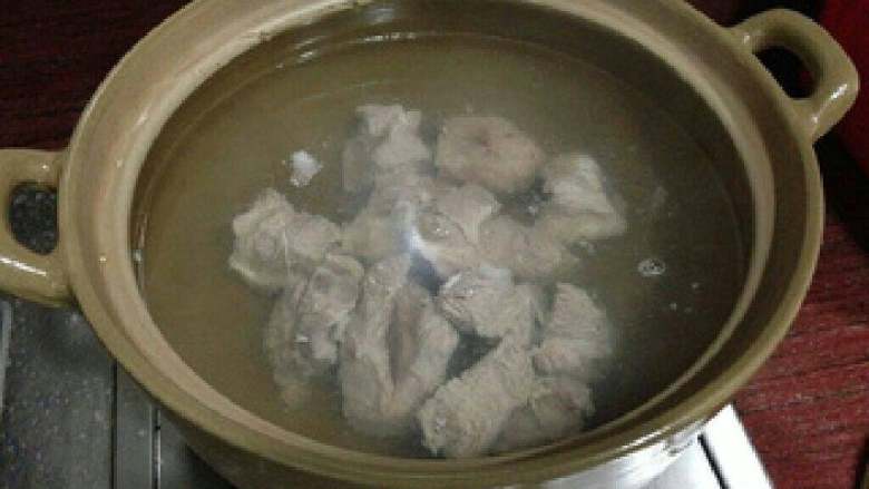 猪骨鱿鱼萝卜汤,砂锅煮开水,放入焯好水的猪骨。