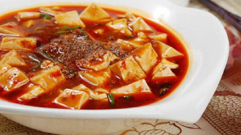 麻婆豆腐,加入少量水、生抽和1小匙糖。用中火开盖烧。不时拌一下。然后改小火焖片刻；开盖勾一个薄芡。翻动一下，收汤；最后撒上黑胡椒、少量辣椒面和剩余的葱末，淋上几滴<a style='color:red;display:inline-block;' href='/shicai/ 5506'>麻油</a>即可；