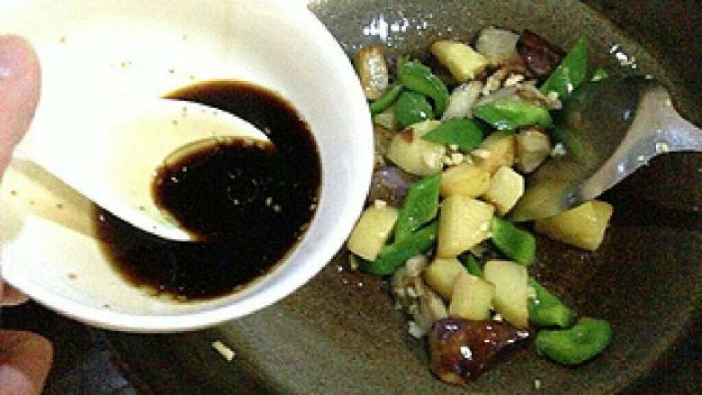 东北地三鲜,放入炸好的土豆、茄子、青椒炒匀,倒入调好的酱汁。