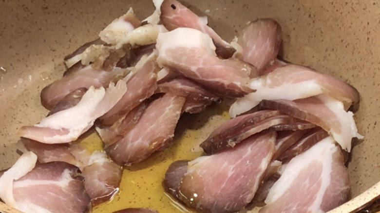 豆干炒腊肉,起锅热油,放入腊肉,煸炒出油至金黄色