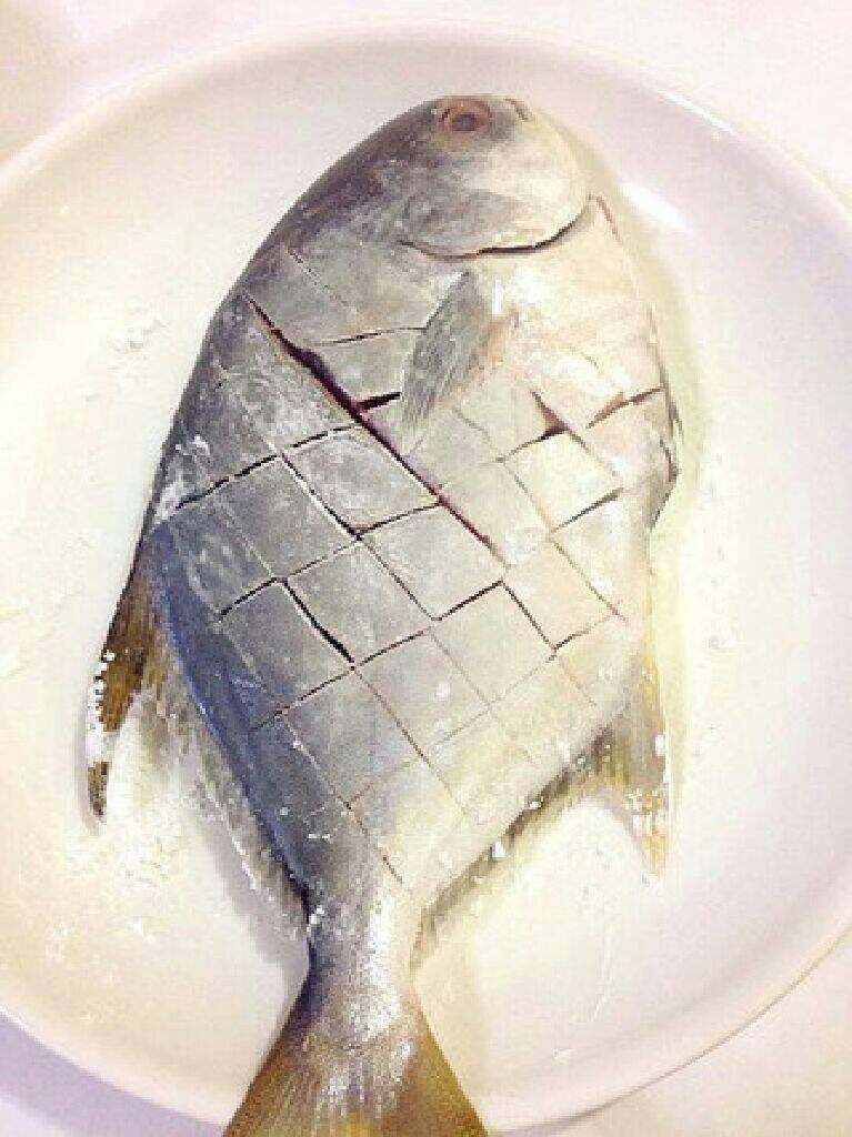 干煸金昌鱼,用厨房纸或者纸巾把金昌鱼表面的水分吸干,两面划十字花刀表面再均匀的拍一层干淀粉