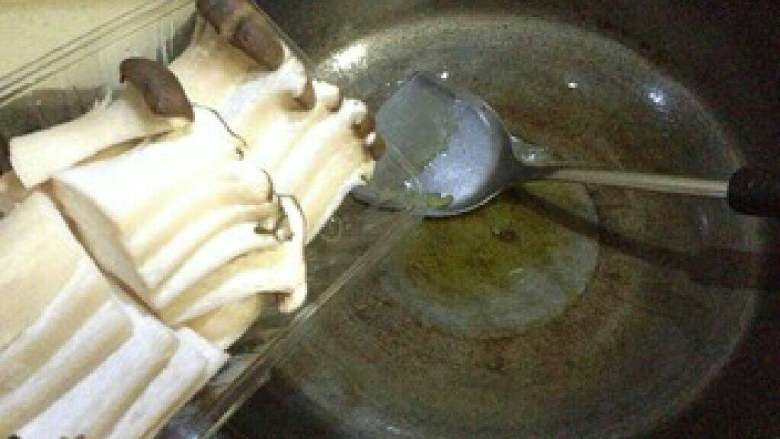 【黑椒培根炒杏鲍菇】,锅内热橄榄油,加入杏鲍菇煎1分钟。