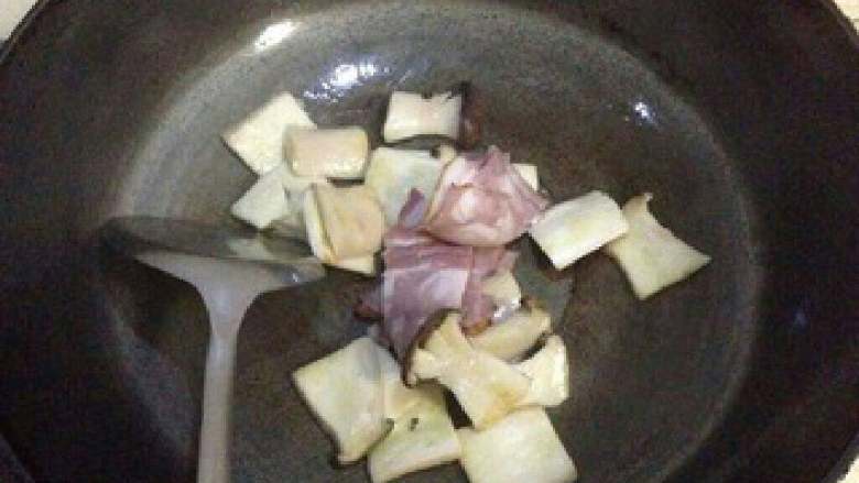 【黑椒培根炒杏鲍菇】, 再加入培根,炒至卷缩出油。