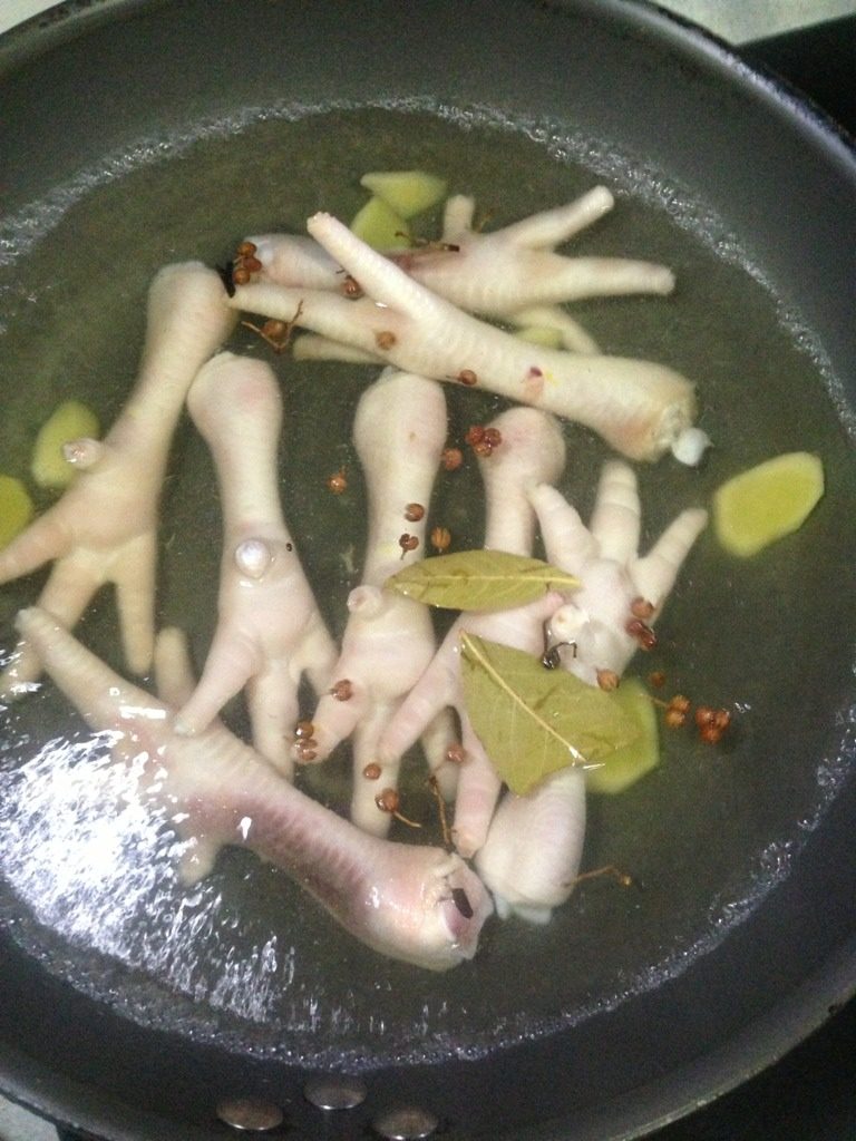 泡椒凤爪,锅中放入调料，烧开，放适量料酒，将鸡爪放入，如图