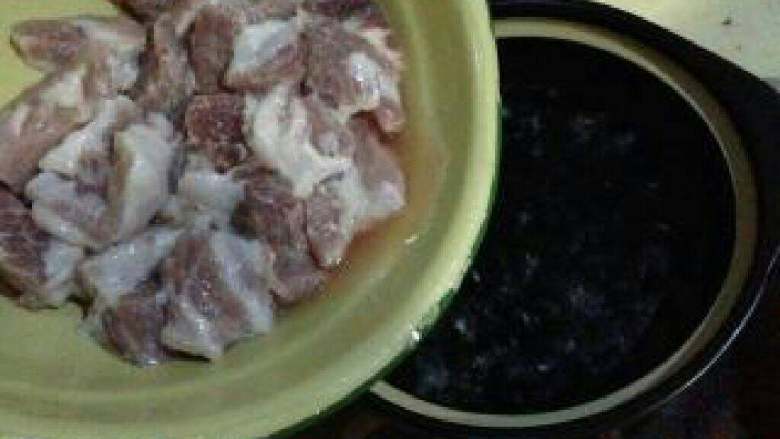 客家菜【土猪肉汤】,砂锅煮开水，把腌过的土猪肉洗掉那些粉。放入砂锅中炖煮。