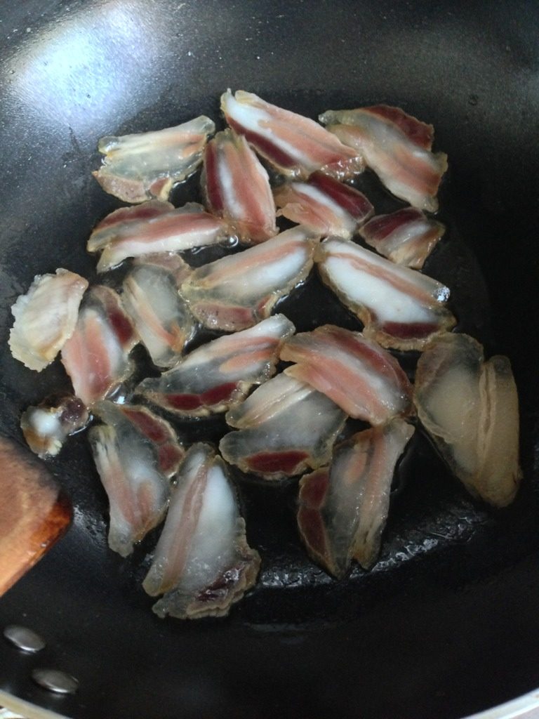 岜夯鸡,点火上锅放适量清油七成热，腊肉切片下锅炒至出油，放<a style='color:red;display:inline-block;' href='/shicai/ 37'>姜</a>，<a style='color:red;display:inline-block;' href='/shicai/ 3766'>草果</a>（要开口），<a style='color:red;display:inline-block;' href='/shicai/ 700'>花椒</a>，<a style='color:red;display:inline-block;' href='/shicai/ 695'>八角</a>，炒出香气，再放辣椒，<a style='color:red;display:inline-block;' href='/shicai/ 85026'>青蒜苗</a>炒拌变色，放酸汤，煮沸。