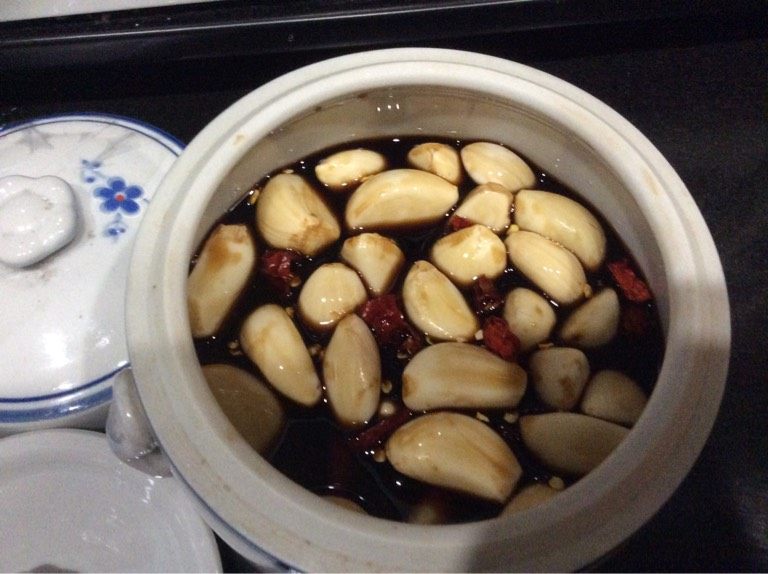 酱油蒜头,等酱油凉了,倒入瓦瓶,然后放蒜头和泰椒,盖上盖子。一个星期后就可以吃啰。