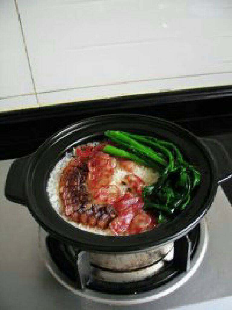 广式腊味煲仔饭,打开锅盖,放入青菜,大火煮1分钟左右。