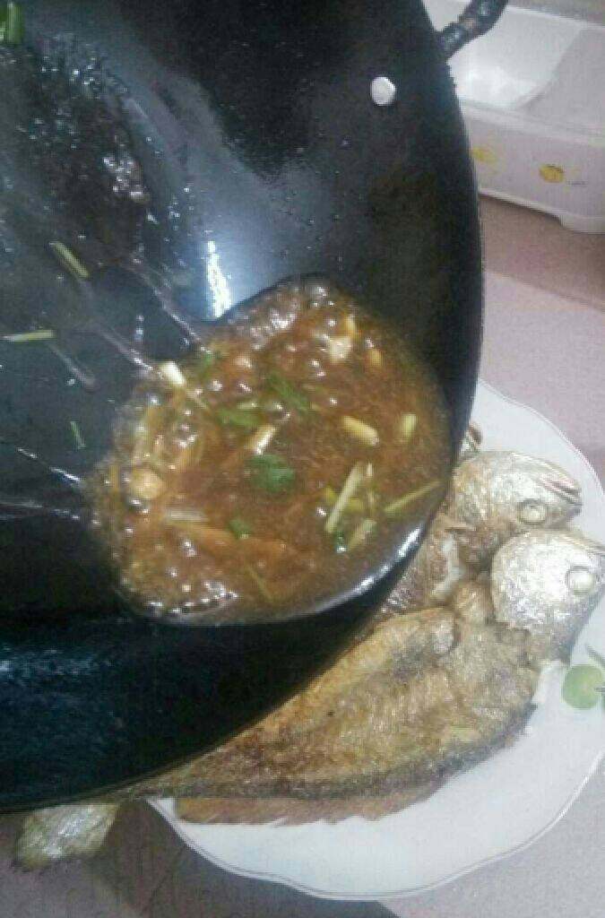红烧黄花鱼,煮开后把汤汁倒在煎好鱼面上