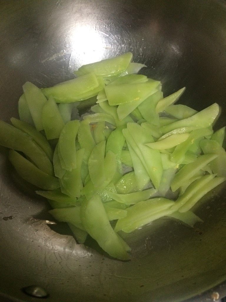 莴笋木耳炒蛋,如图锅中再倒入少许油，下莴笋片煸炒，加盐和糖继续煸炒；