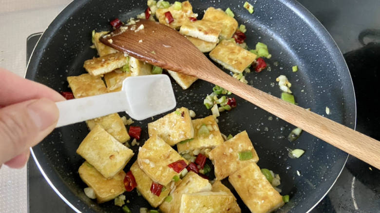 椒盐豆腐,加入半茶匙<a style='color:red;display:inline-block;' href='/shicai/ 3729'>白糖</a>少许食盐,翻炒均匀