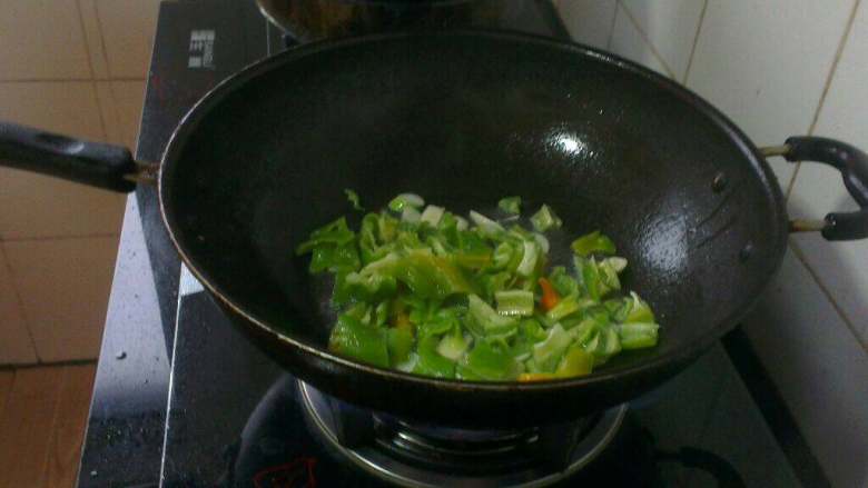 青椒炒鸡腿菇,炒锅放油烧热,放入葱蒜片炒香;再倒入青椒翻炒均匀;