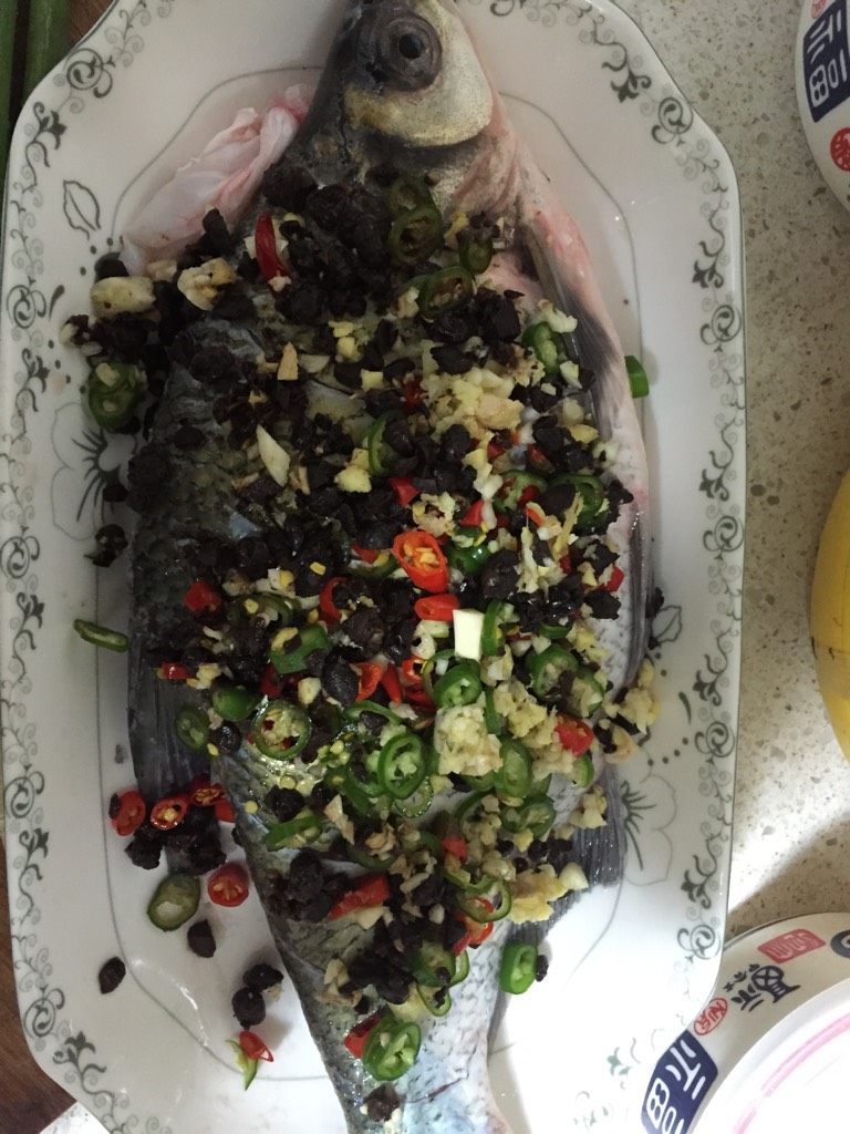 豆豉鱼,待鱼表面干爽时取下，将<a style='color:red;display:inline-block;' href='/shicai/ 694'>豆豉</a>放入鱼肚中，鱼身表面也放上<a style='color:red;display:inline-block;' href='/shicai/ 694'>豆豉</a>，再将青红椒丁和姜蒜末混合，均匀的洒在鱼身上。