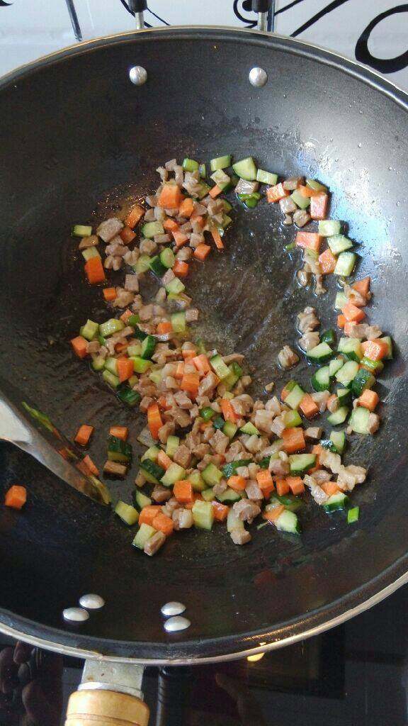 羊肉炒饭,加入胡萝卜和黄瓜丁翻炒至胡萝卜变软