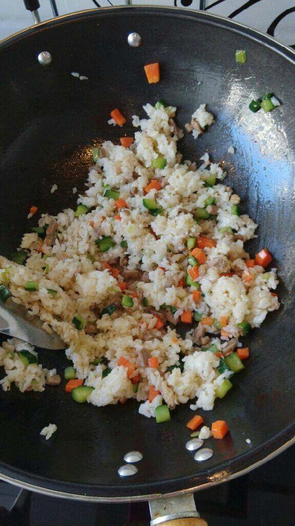 羊肉炒饭,加入米饭翻炒均匀，再加入盐调味继续翻炒至米饭都散开