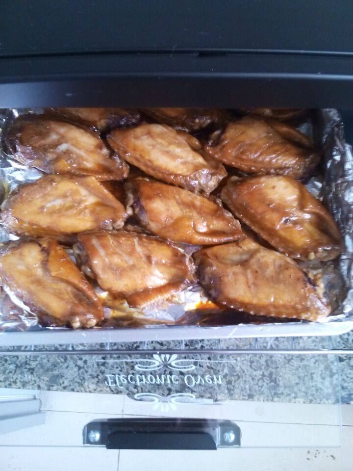 烤箱鸡翅,5分钟后，再次打开烤箱，将鸡翅翻面，刷上蜂蜜，再烤5分钟。