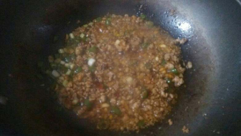 肉末蒸茄子,再倒入肉末煸炒,沿锅边烹入料酒。加入鲜味酱油,一小勺白糖。加入少许水淀粉,小火煮几分钟。