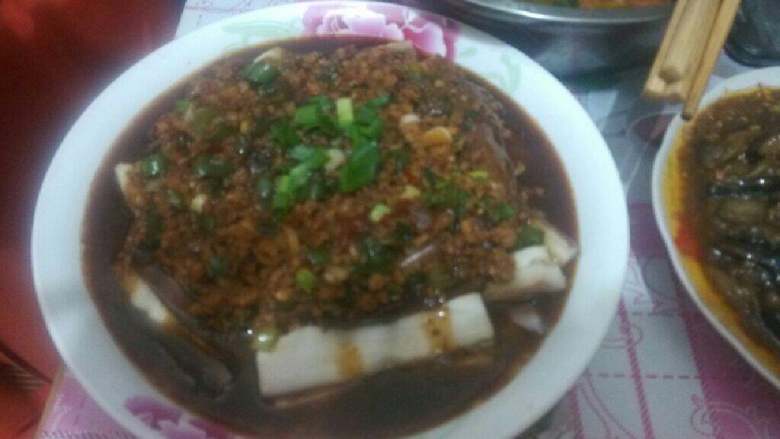 肉末蒸茄子,炒好的肉末连汁均匀的浇在蒸好的茄条上。最后再撒上些香葱末即好。