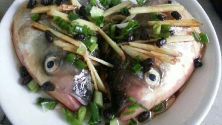 豆豉清蒸鱼头,将油1勺、盐1小勺、<a style='color:red;display:inline-block;' href='/shicai/ 212520'>蒸鱼豆豉</a>2勺、葱、<a style='color:red;display:inline-block;' href='/shicai/ 128224'>黑豆豉</a>几粒、姜丝分别加入鱼头面上。