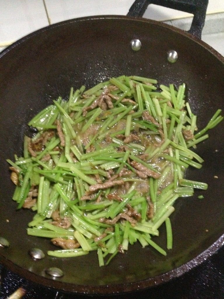肉丝炒芹菜,放入芹菜，调入适量盐，鸡精，如图