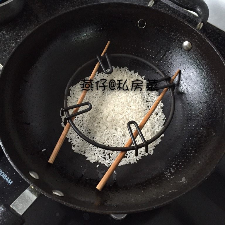 米熏鸭肉,如图锅里放入米,用筷子支撑在上面。