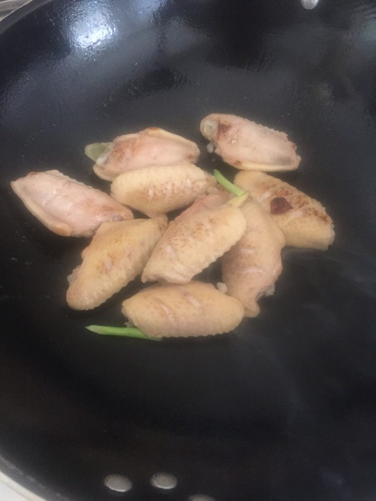 可乐鸡翅,然后放入八角香、蒜、姜片翻炒