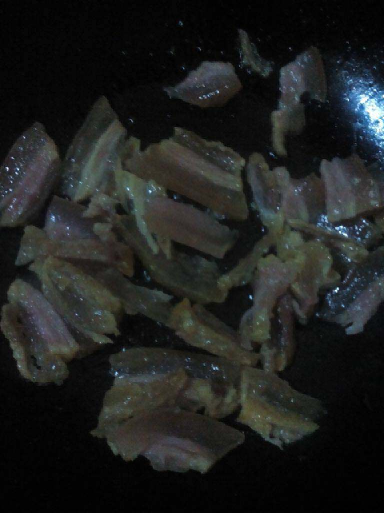 腊肉炒土豆片,锅中热油加入腊肉翻炒至透明