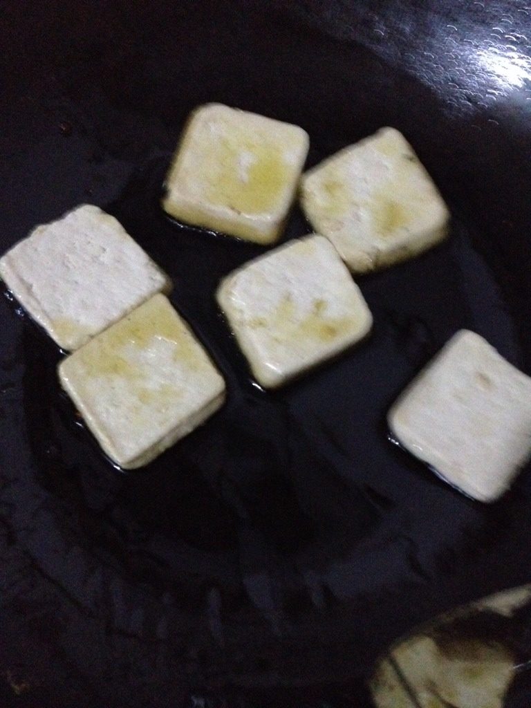 臭豆腐,如图锅底少放点油。一片一片的放进去烙