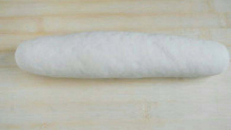 牛奶刀切馒头,将醒发好的面团排出空气，用擀面杖擀成均匀的薄片。卷成一条。